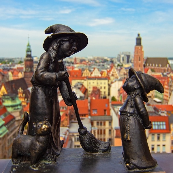 Wroclaw, Poland - 06.18.2023: Wroclaw gnomes Tekla and Martynka (aka Czarownice Tekla i Martynka) on the Penitents Bridge (aka Mostek Pokutnic) between towers of St. Mary Magdalene's Church